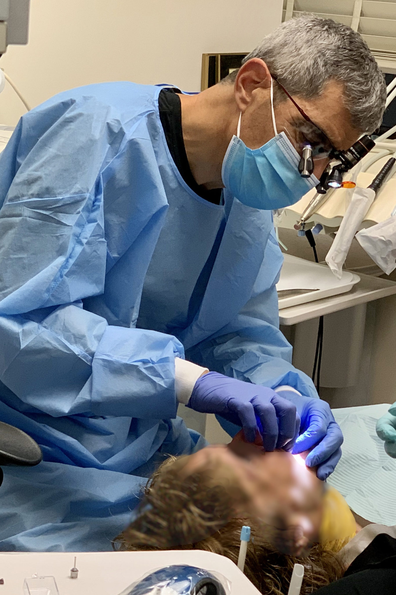 Dr. Andy placing minimally invasive implant into patient's mouth