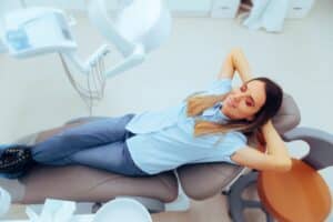 Woman relaxes at the dentist, letting go of the dental anxiety