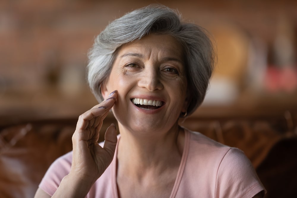 Older woman with nice teeth thanks to ceramic veneers.