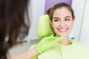 Smiling patient in her late teens had a pain-free laser dentistry appointment to address a cavity.